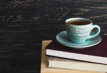 Cup of hot tea and books on wooden table. Background with copy Space.の写真素材