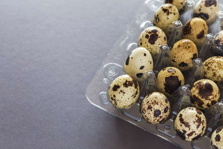 Quail eggs in a clay bowl on dark stone table. Close-upの写真素材