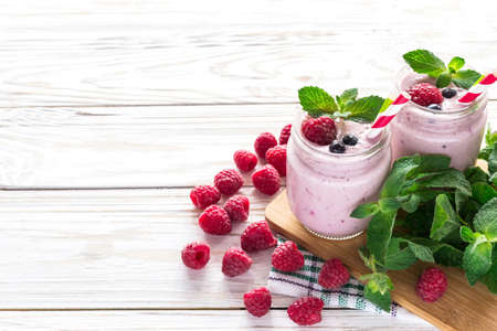 Raspberries fruit smoothie with mint or milk shake in glass jar with wooden background.の写真素材