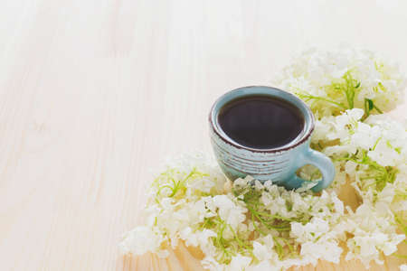 Cup of coffee and white hydrangea on wooden table, backgroundの写真素材