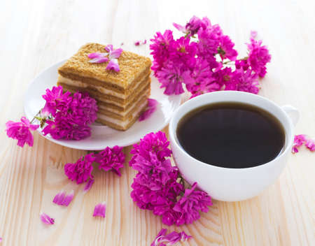 Napoleon cake, cup of coffee and pink garden roses on wooden tableの写真素材