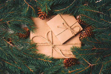 Christmas background. Craft gift boxes and decoration - Christmas tree branches and cones on slate marble background. Flat lay, copy space, top view.の写真素材