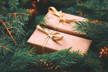 Christmas background. Craft gift boxes and decoration - Christmas tree branches and cones on slate marble background. Flat lay, copy space, horizontal view.の写真素材