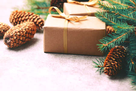 Christmas background. Craft gift boxes and decoration - Christmas tree branches and cones on slate marble background. Flat lay, copy space, horizontal view.の写真素材
