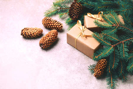 Christmas background. Craft gift boxes and decoration - Christmas tree branches and cones on slate marble background. Flat lay, copy space, top view.の写真素材