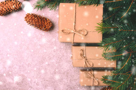 Christmas background. Craft gift boxes and decoration - Christmas tree branches and cones on slate...