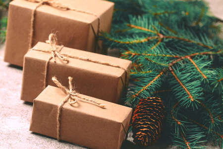 Christmas background. Craft gift boxes and decoration - Christmas tree branches and cones on slate marble background. Flat lay, copy space, horizontal view.の写真素材