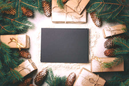 Christmas background. Craft gift boxes and decoration - Christmas tree branches and cones on slate marble background. Flat lay, copy space, top view.の写真素材