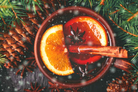 Hot mulled wine with apples, pomegranate, orange, anise and cinnamon with fresh fruits on slate marble background. Flat lay, copy space, top view. Christmas and holidays foodの写真素材
