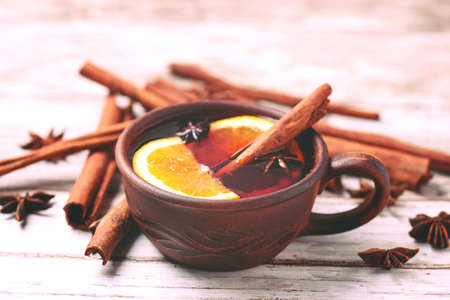 Hot mulled wine with apples, pomegranate, orange, anise and cinnamon with fresh fruits on slate marble background. Flat lay, copy space, top view. Christmas and holidays foodの写真素材