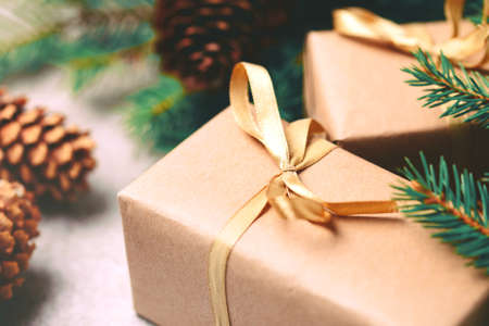 Christmas background. Craft gift boxes and decoration - Christmas tree branches and cones on slate...