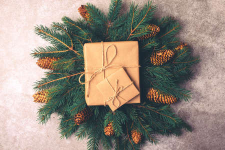 Christmas background. Craft gift boxes and decoration - Christmas tree branches and cones on slate marble background. Flat lay, copy space, top view.の写真素材