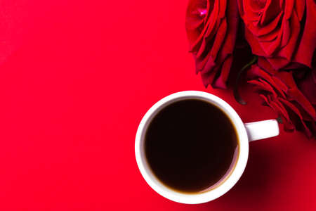 Espresso coffee and beautiful layout of roses on red background. Flat lay, copy space, top view. Color surge trend. Valentine's day conceptの写真素材
