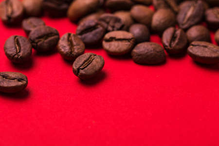 Roasted coffee beans isolated on red background. Color surge trend. Macroの写真素材