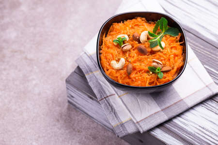 Traditional Indian cuisine. Homemade carrot Gajar halwa on orange background. Copyspace, top view, flatlayの写真素材