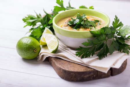 Traditional Indian cuisine of colonialists. Homemade Mulligatawny cream-soup with lentil, parsley, cream and chicken on wooden background. Copyspace, horizontal view.の写真素材