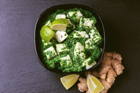 Traditional Indian cuisine. Homemade palak paneer on black slate background. Copyspace, top view