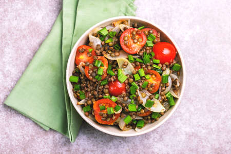 Traditional Indian cuisine. Lentil salad with green onion, cherry tomatoes, ginger and lime on gray slate background. Healthy food, vegetarian and vegan snack, clean eating, diet, detox.  Copyspace, top viewの写真素材
