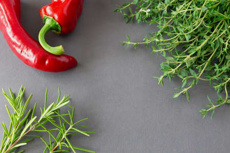Bunch of fresh organic thyme, rosemary and red chili on a rustic backgroundの写真素材