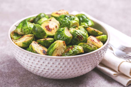 Vegetarian cuisine. Homemade Brussels Sprouts roasted with olive oil on gray slate background. Copyspace, horizontal view, flatlay.の写真素材