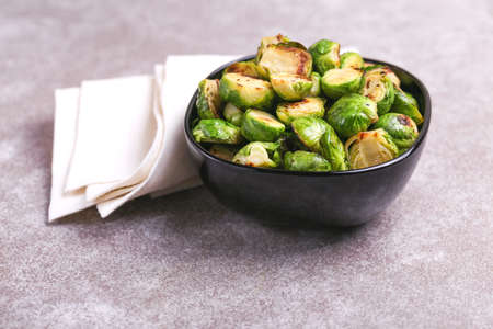 Vegetarian cuisine. Homemade Brussels Sprouts roasted with olive oil on gray slate background. Copyspace, top view, flatlay.の写真素材