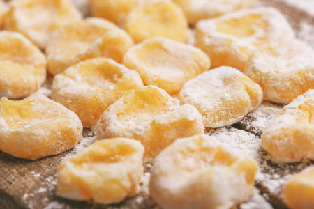 Traditional Italian cuisine. Uncooked homemade potato gnocchi on vintage cutting board with flour. Copyspace, horizontal viewの写真素材