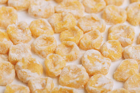 Traditional Italian cuisine. Uncooked homemade potato gnocchi on vintage cutting board with flour. Copyspace, horizontal viewの写真素材