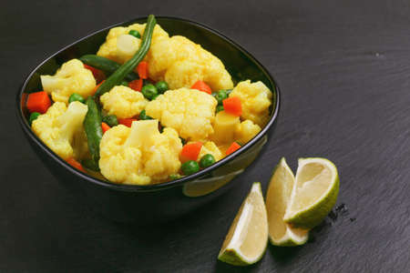 Traditional Indian cuisine. Vegetarian creamy coconut curry Vegetable Korma with spices and herbs. Copyspace, horizontal view, flatlayの写真素材