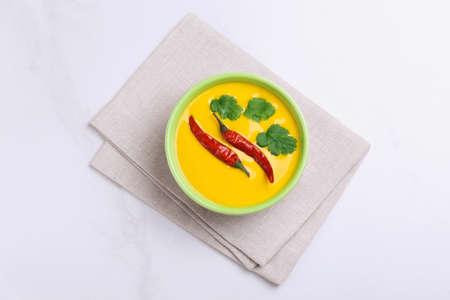 Traditional Indian cuisine. Vegetarian curry Gujarati Kadhi with chickpea gravy and sour yogurt. Copyspace, top view, flatlayの写真素材