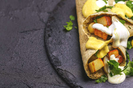 Traditional Indian cuisine. Vegetarian masala dosa with fried potato filling and chutney and sambar sauces. Copyspace, top view, flatlayの写真素材