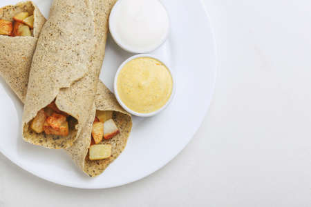 Traditional Indian cuisine. Vegetarian masala dosa with fried potato filling and chutney and sambar sauces. Copyspace, top view, flatlayの写真素材