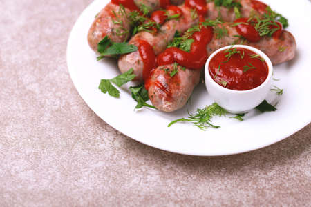 Summer food. Grilled homemade sausages with dill, parsley and lime on black stone. Copyspace, horizontal viewの写真素材