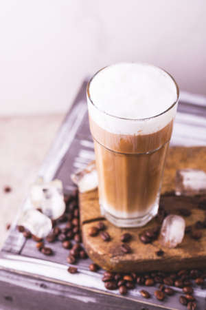 Iced coffee in glasses with milk and cream. White background, wooden table. Top view. Copy spaceの写真素材