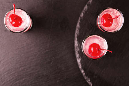 Alcoholic shot cocktail sour cherry gin or porch crawler with liqueur and lime. Black background....
