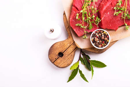 Fresh raw beef tenderloin and marbled steaks on wooden cutting board with seasoning. Top view.の写真素材