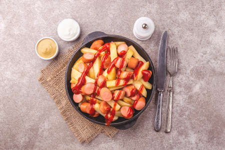 Traditional homemade Peruvian Salchipapa Fries with mayo, ketchup and mustard sauces. French fries...