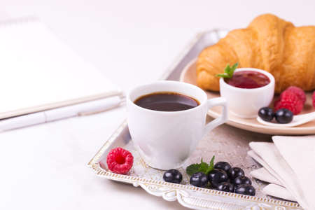 Cup of hot coffee, croissant, plaid and books on table. Education concept. Selective focusの写真素材