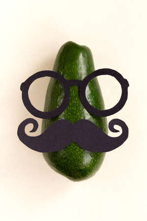 Funny male silhouette pattern on the yellow background. Cute party face with avocado. Prostate Cancer and men's health awareness.の写真素材