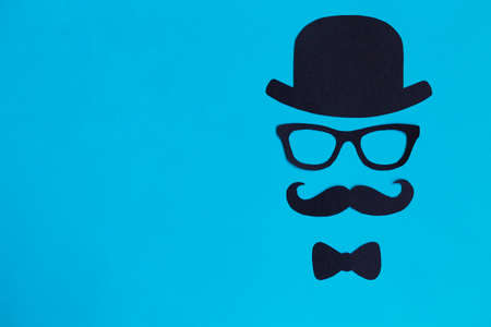 Male silhouette with mustache, glasses and hat patterns on the blue background. November concept....