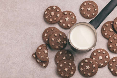 Chocolate cookies with jar of hot milk on the gray slate background. Top view. Cozy evening. Copy spaceの写真素材