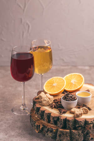 White and red mulled wine with ingredients on the wooden cutting board. Christmas or winter warming drink. Copy spaceの写真素材