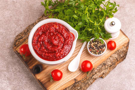 Bright fresh tasty pureed tomato soup in clay bowl with ingredients. Healthy food concept. Gray marble background. Copy spaceの写真素材