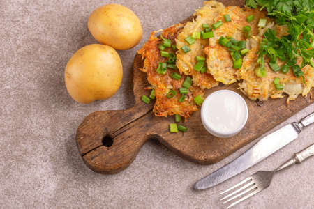 Homemade traditional potato pancakes or latke Hanukkah celebration food with ingredients on vintage...