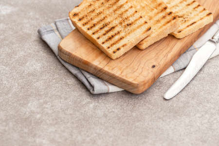 Crispy toasts for breakfast on the grey slate background with knife and napkin. Horizontal viewの写真素材