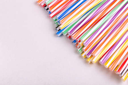 Colorful plastic straws on light background. Event and party supplies. Earth pollution conceptの写真素材