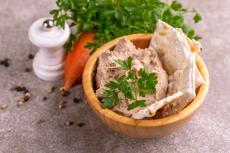 Pieces of matzah with homemade liver pate with parsley and onion on  gray marble background. Horizontal view. Copy spaceの写真素材