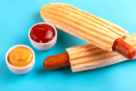 Two grilled french hot dogs with mustard and ketchup on bright background. Junk or fast food. Copy spaceの写真素材