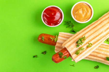 Two grilled french hot dogs with mustard and ketchup on bright background. Junk or fast food. Copy spaceの写真素材
