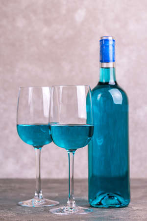 Two glasses and bottle of trendy blue wine. Spanish blue wine chardonnay on dark concrete background. Romantic dateの写真素材