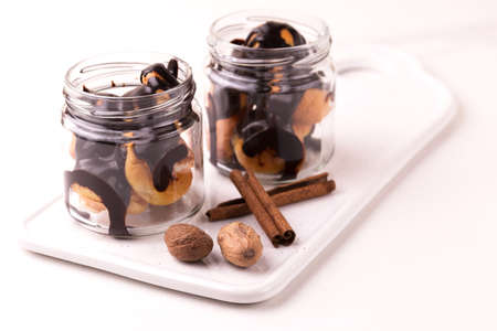 Homemade cake eclairs. Traditional french profitroles with chocolate in glass jar. Dessert....
